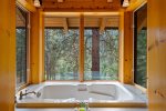 Hot tub with forest views to merge into nature for total relaxation.